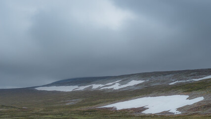 Fototapeta na wymiar Gräftåvallen. Mountain slope covered with clouds