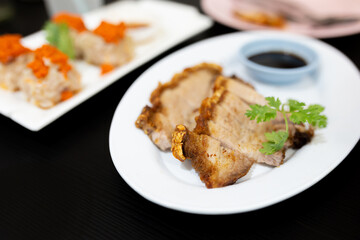 Fried pork crackling on white disk, asian food culture