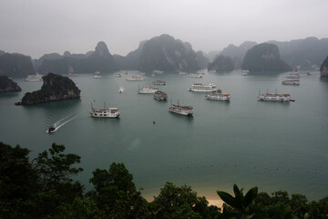 Fototapeta premium Picturesque view of UNESCO Ha Long bay. Tourist boats are swimming near chicken rocks.