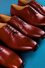 Brown oxford shoes on blue background, flat lay