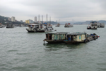 Fototapeta na wymiar Picturesque view of UNESCO Ha Long bay. Tourist boats are swimming near chicken rocks.