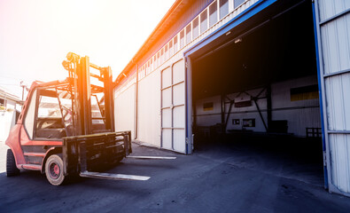 The big industrial forklift drives into the warehouse. © romaset