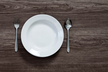 empty plate and spoon on wooden table