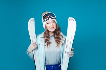 fun skier is preparing to ski. Young woman in equipment and with skis,
