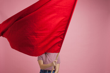 activist and revolutionary, young woman with a red flag on a pink background.