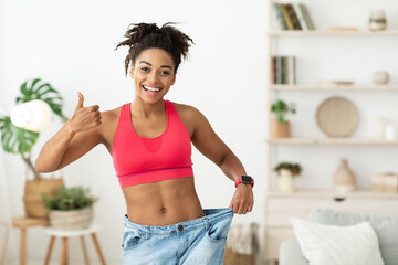 Slim African American Girl Gesturing Thumbs-Up Approving Diet Standing Indoor