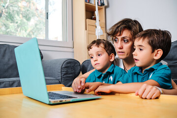 a mother using a computer to teach their children at home