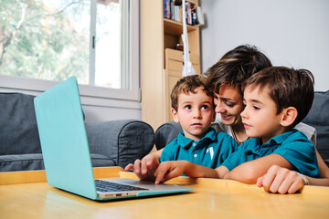 a mother using a computer to teach their children at home