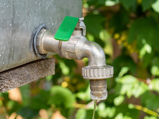 open water faucet or tap with flowing water in blur garden background