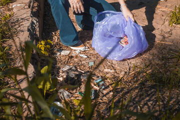 Cleaning up garbage, volunteer work. Caring for nature. People left a lot of plastic garbage in the...