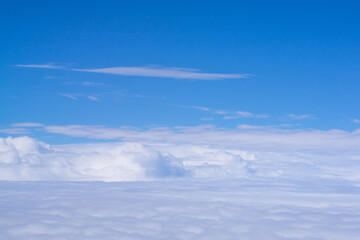 Naklejka na ściany i meble Aerial view of cloudscape seen through airplane window