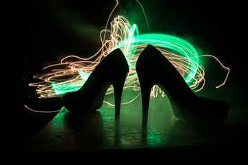 Silhouette of a high heel women shoes at dark. Women power or women domination concept.