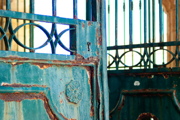 Antique green colored metal door, very rusty and worn