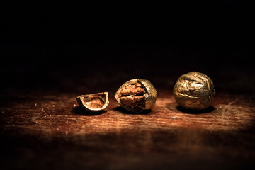 Still life with Walnut kernels and whole walnuts on rustic old wooden table. Creative table decoration.