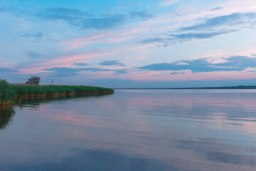 Fototapeta premium colored sunset over the river, with sky reflection