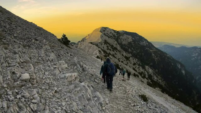 Olymp, Greece - 22 Jul, 2018: The climbers go down from the rocky summit Mytikas highest Olympos peak at sunset