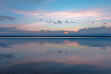 Fototapeta premium colored sunset over the river, with sky reflection