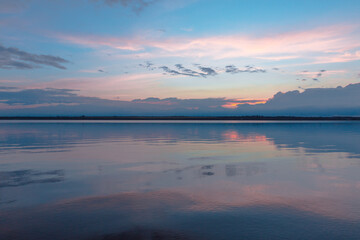 Fototapeta premium colored sunset over the river, with sky reflection