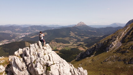 man  on a mountain summit taking a picture. Urkiola, basque country, spain