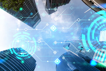 Technology hologram on low, wide angle view of glass and steel contemporary skyscrapers in financial downtown . The concept of developing coding and high-tech science. Double exposure.