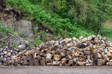 Logging for kindling the stove in the house lie on the background of the rocky mountains.