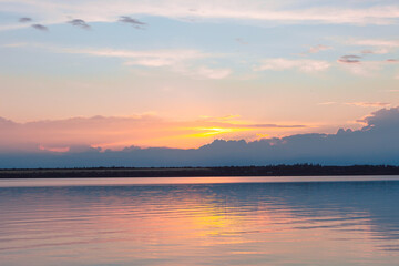 colored sunset over the river, with sky reflection
