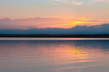 colored sunset over the river, with sky reflection