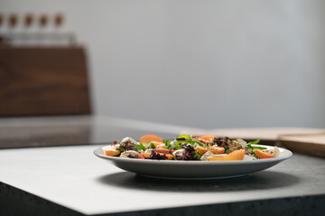 Closeup salad with nectarines, mozzarella and mixed greens in white plate on concrete countertop