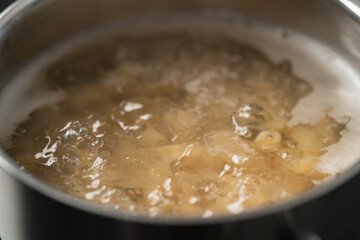 Cooking fusilli in boiling water closeup