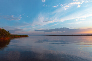 Fototapeta premium colored sunset over the river, with sky reflection
