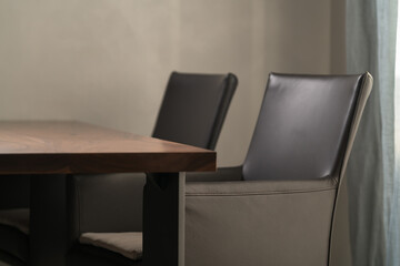 Minimalist kitchen interior with walnut dining table and leather arm chairs