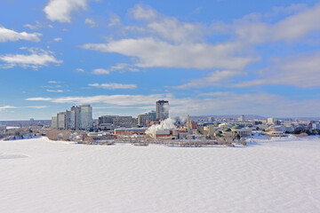 Highrise office towers, industrial buildings and national history museumin Hull district in winter, along frozen Ottawa river.