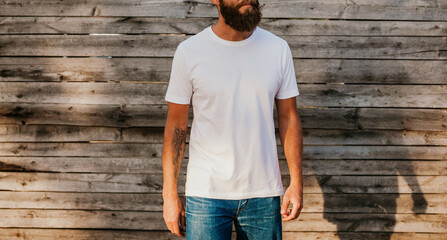 Young bearded hipster guy wearing white blank t-shirt. Mock-up for print. T-shirt template.
