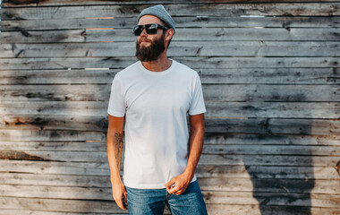 Young bearded hipster guy wearing white blank t-shirt. Mock-up for print. T-shirt template.
