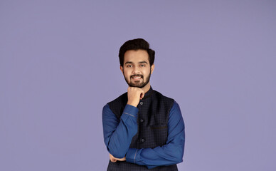 Portrait of attractive Indian man propping chin with his hand on lilac background