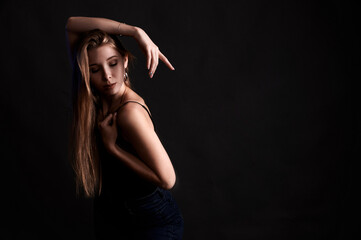 Girl on a black background in fashionable clothes