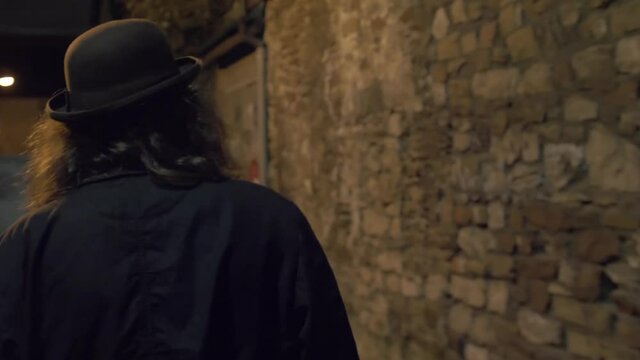 An stereotypic detetive / inspector observing a dark alley by night
