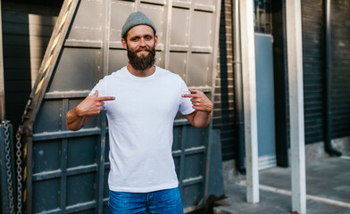 Young bearded hipster guy wearing white blank t-shirt. Mock-up for print. T-shirt template.