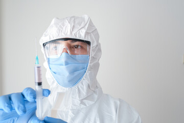 fully sheltered doctor holding syringe in hand. Young doctor preparing for vaccination.