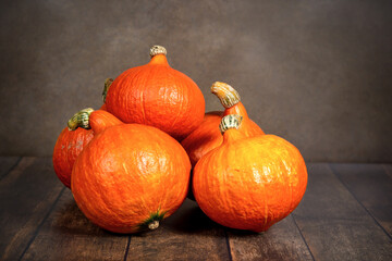 Ripe orange pumpkins on the table on a dark background.