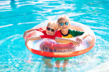 Kids in swimming pool. Life jacket for child.