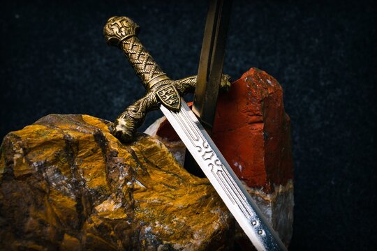 Knight's sword against a background of red and brown stones