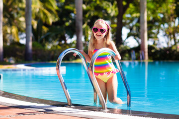 Child in swimming pool with ball. Kids swim.