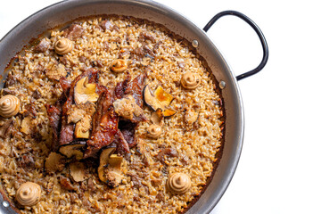 Rice with meat and mushrooms on a frying pan