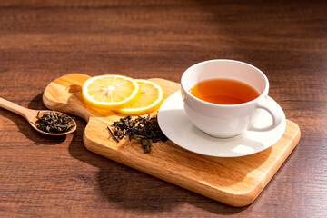 Cup of freshly tea with yellow lemon on black