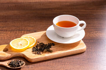 Cup of freshly tea with yellow lemon on black