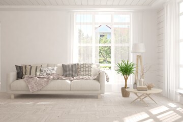Fototapeta premium White living room with sofa and summer landscape in window. Scandinavian interior design. 3D illustration