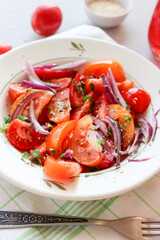 Sliced tomatoes with red onion, spices in oil