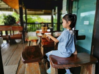A little girl drinking  water in a cafe