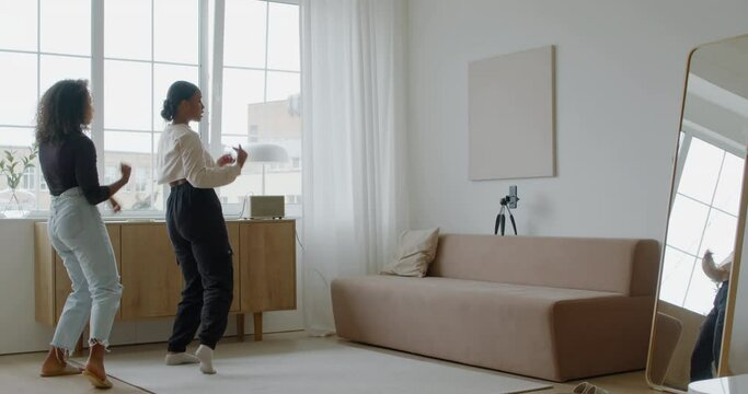 Two African-American Black girls recording trendy dance moves for social media account